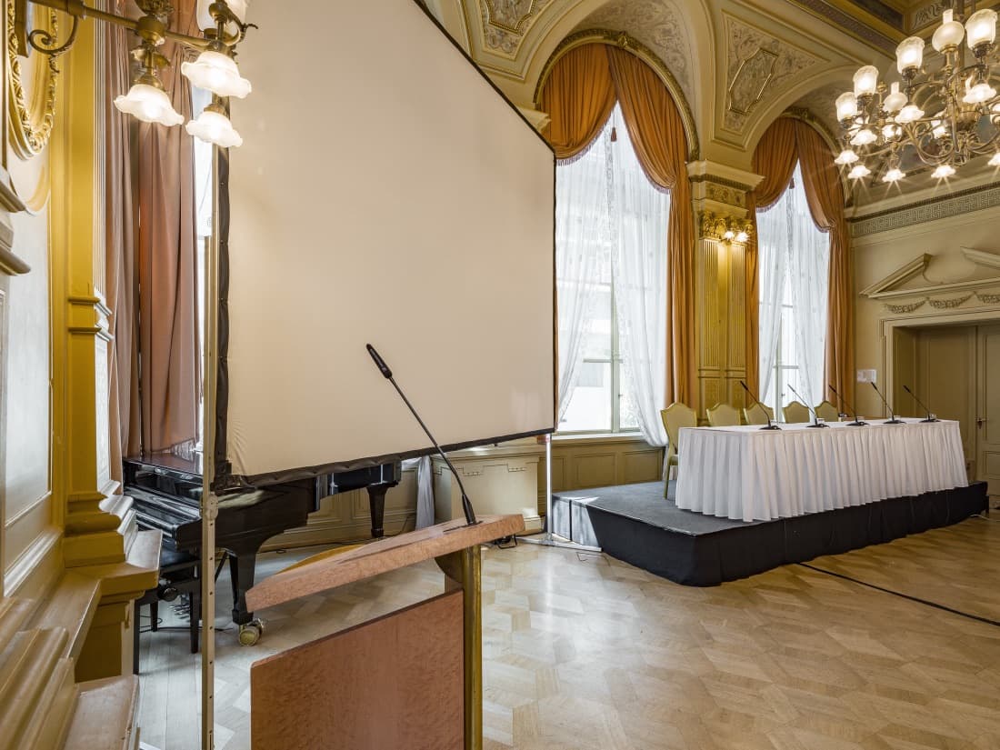 Konferenz-Setup mit Bühne, Rednerpult und Leinwand im Spiegelsaal